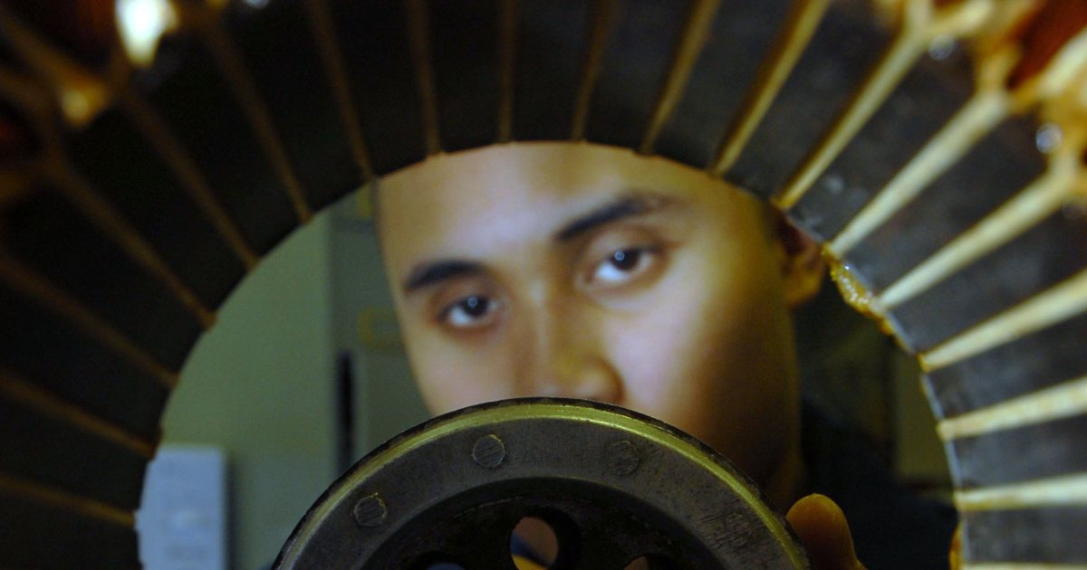 Stator sargısı içinden motor rotorunu inceleyen teknisyen