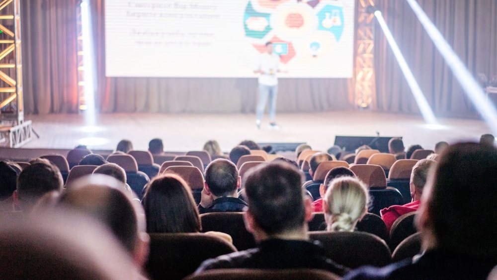 Sahnedeki sunumu izleyen konferans katılımcıları