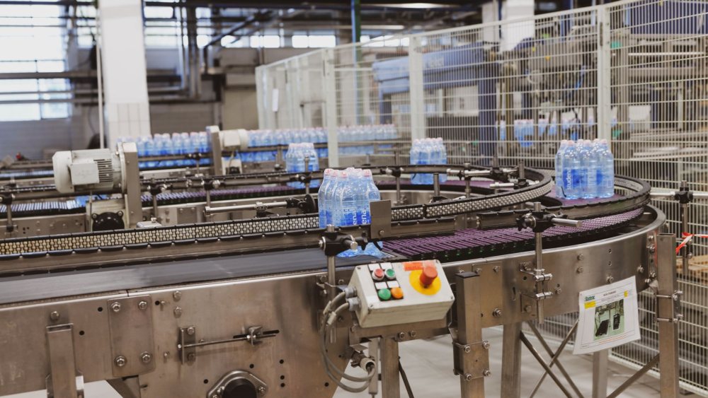 Dolum hattında paketlenmiş ürünler taşıyan konveyör