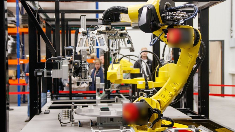 Montaj hattında çalışan sarı endüstriyel robot kol