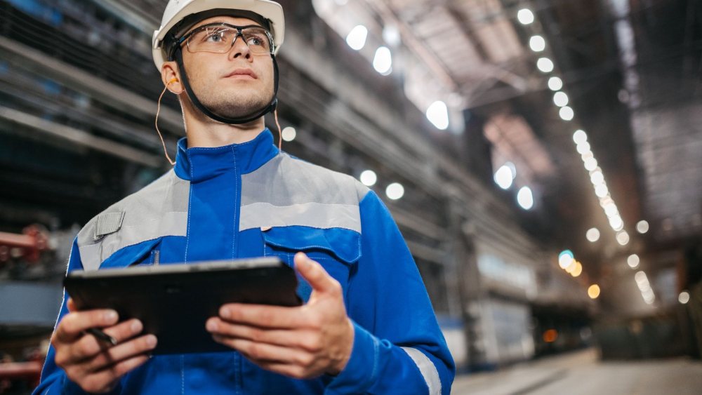 Fabrika sahasında tablet ile kayıt tutan teknisyen